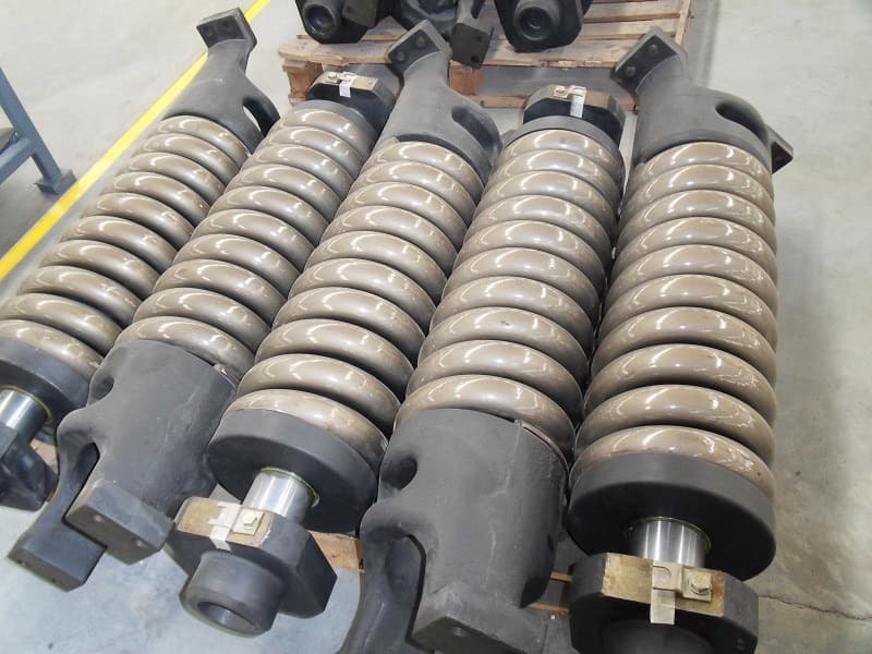 Track adjuster and recoil spring assemblies arranged for product identification